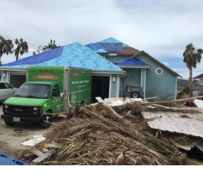 SERVPRO truck in front of storm damaged home.