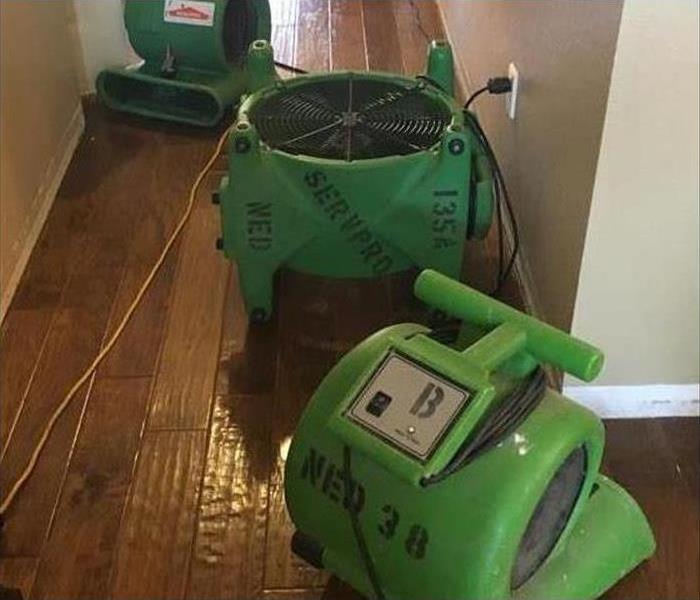 Three air movers or fans on wooden floor