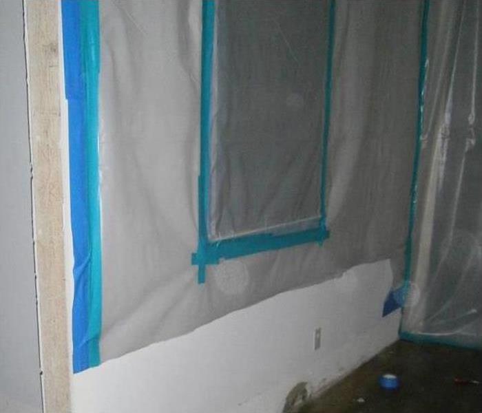 Plastic covers placed on a wall for containing mold 